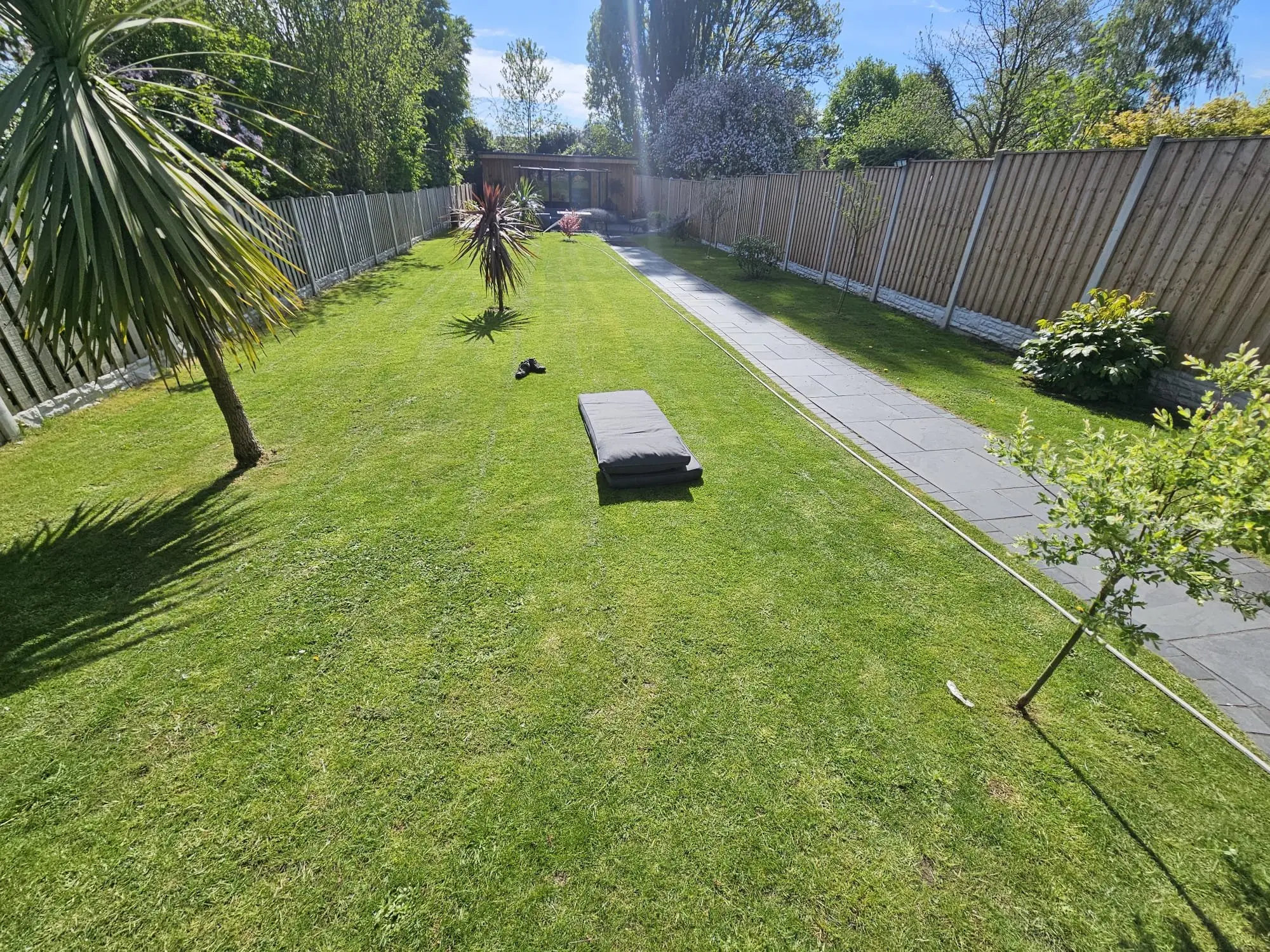 Rear garden with slate patio, gabion walls, and timber screening