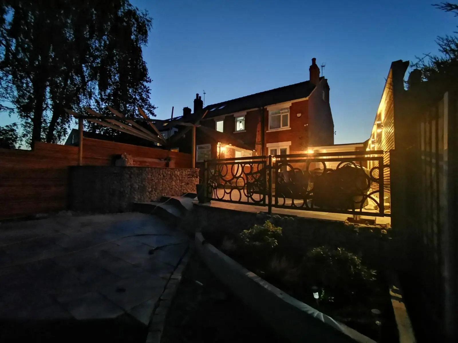 Rear garden with slate patio, gabion walls, and timber screening