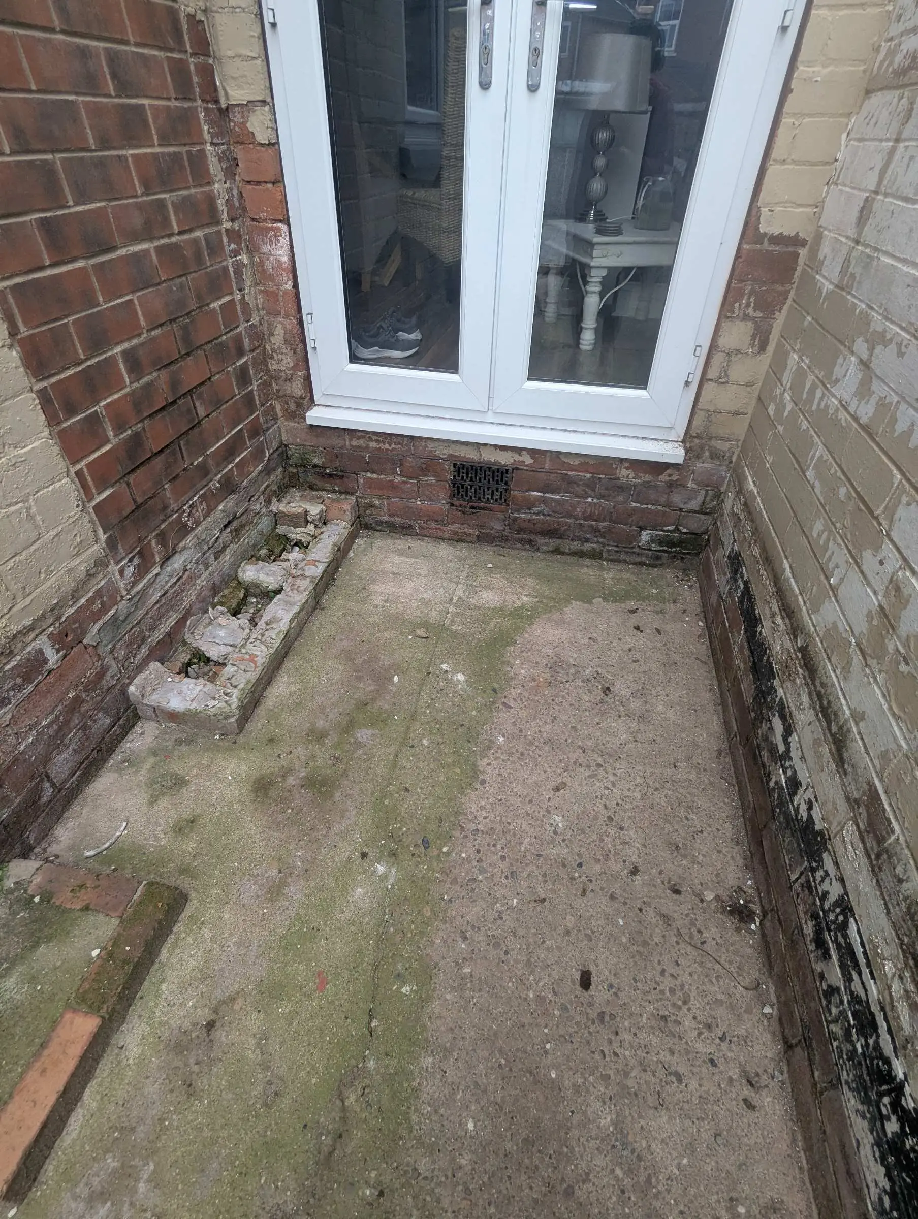 Narrow concrete passage beside the house